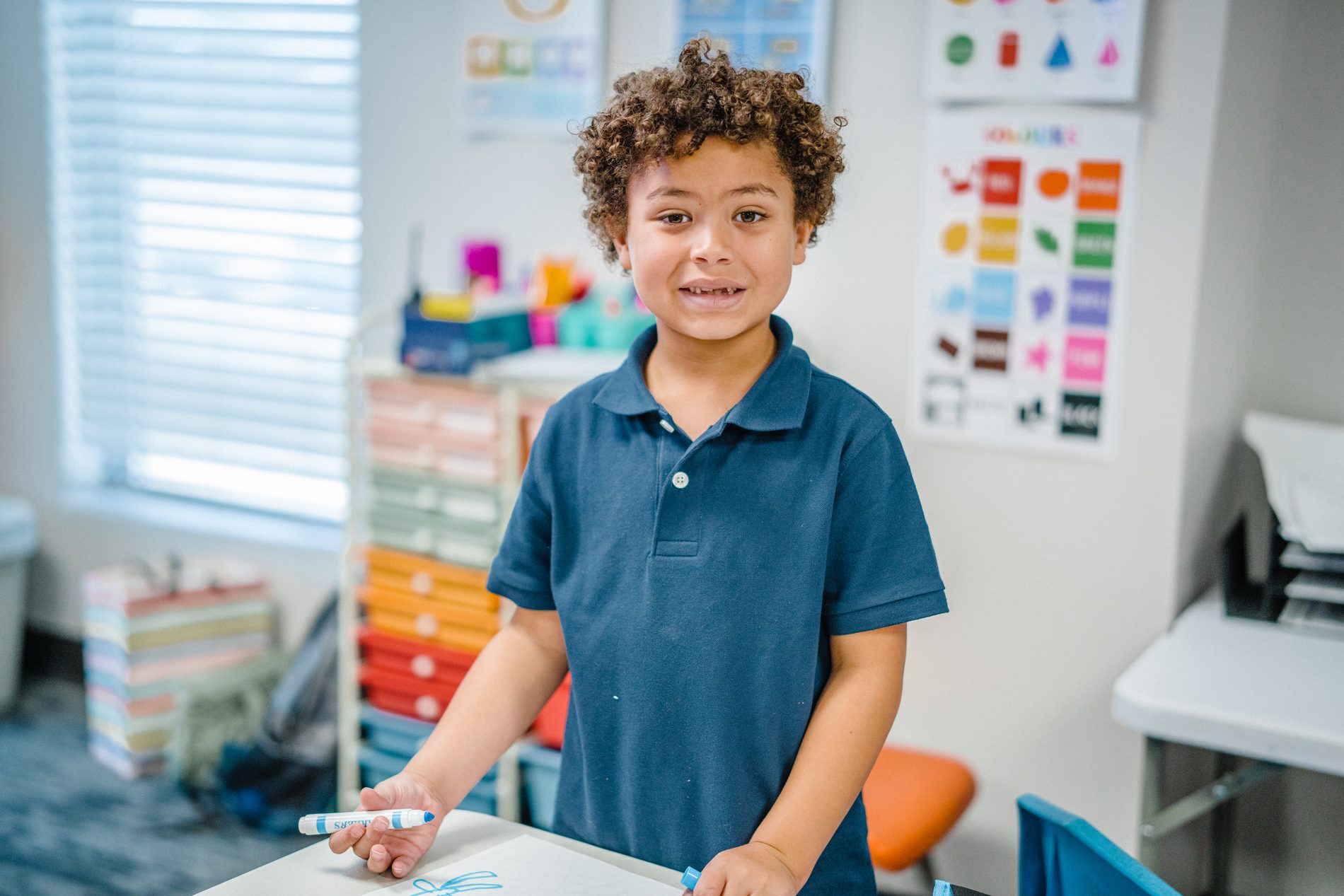A student smiling at a classroom whiteboard